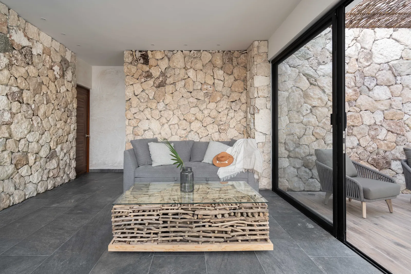 Living room with stone wall and floor-to-ceiling glass at Villas Twelve #4